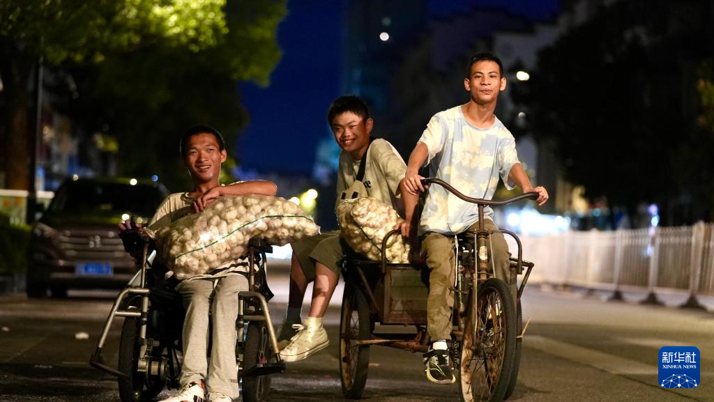 三名小伙在出摊的路上。新华社记者胡晨欢 摄