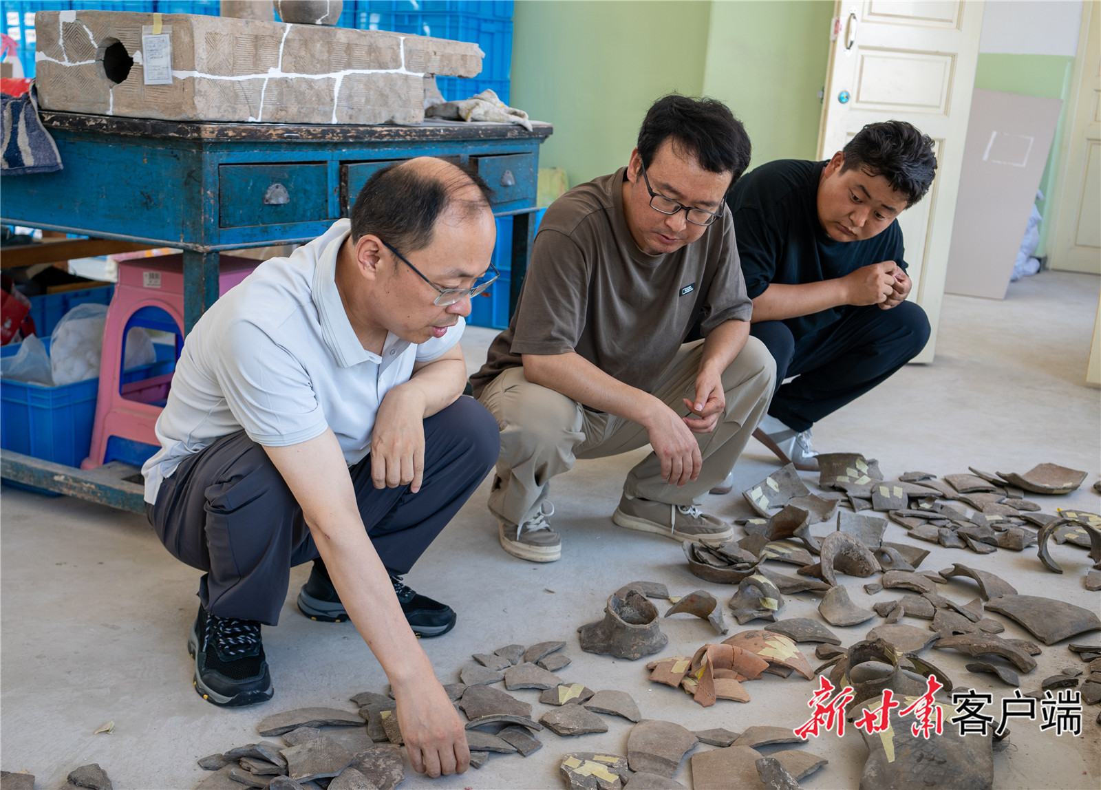 侯红伟（左一）和同事仔细查看正在修复中的文物　新甘肃&middot;甘肃日报通讯员　樊一航