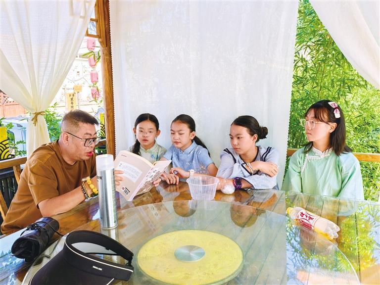 万小藤（右一）和其他小演员们听导演讲戏