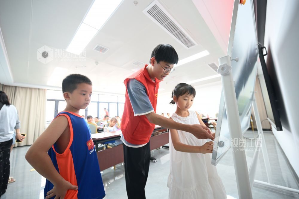 2025年8月5日，在江西省吉安市吉州區城北綜合體服務大樓，大學生志愿者正在為暑期公益托管班的孩子們解答問題。