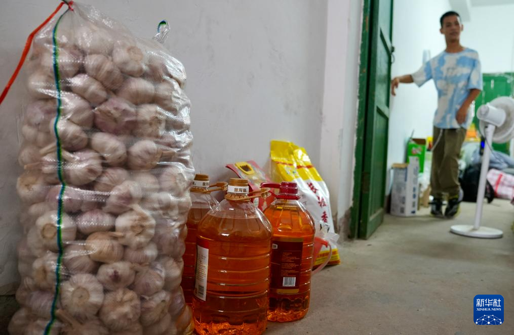 大蒜旁摆放着政府和爱心人士赠送给他们的部分油和米。新华社记者 胡晨欢 摄