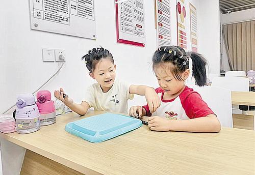 8月8日,在石家庄市新华区明珠花苑社区公益托管班,两位小朋友正在玩游戏。本报记者 贾梦宇摄