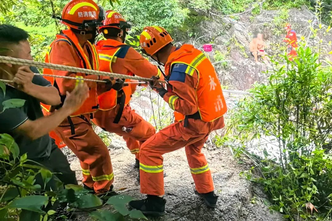 4消防员及现场群众齐齐拉动绳索将被困游客拉往安全区域.jpg