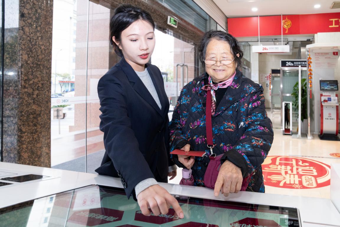 分行营业部客服经理帮助老年人更好地融入“数字社会”，共享智能金融服务的快捷与便利。（胡月摄）