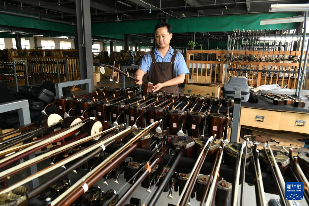 8月19日，工人在河北省肃宁县一家乐器生产企业车间内制作二胡。