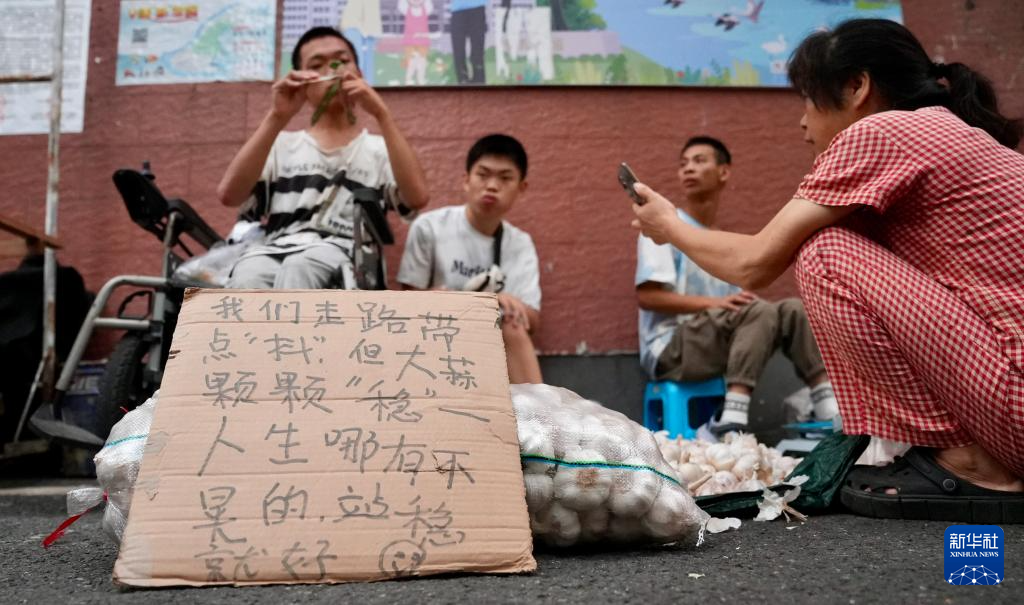 摊前摆放着他们的宣传语。新华社记者 胡晨欢 摄