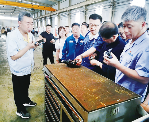 劳模工匠在生产一线进行技术研讨