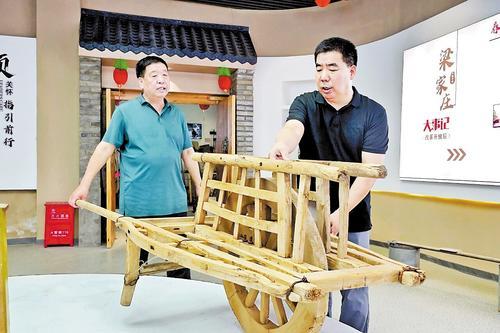 8月15日，宁晋县政协常委孟琴锋（右）在大陆村镇南梁庄村村史馆与村民商议村史馆物品陈列情况。 本报记者 刘冉摄