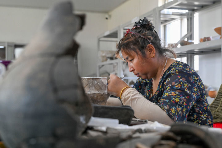 2025年5月20日，考古工作者在大汶口遗址考古工作站对出土器物进行修复。新华社记者 陈朔 摄