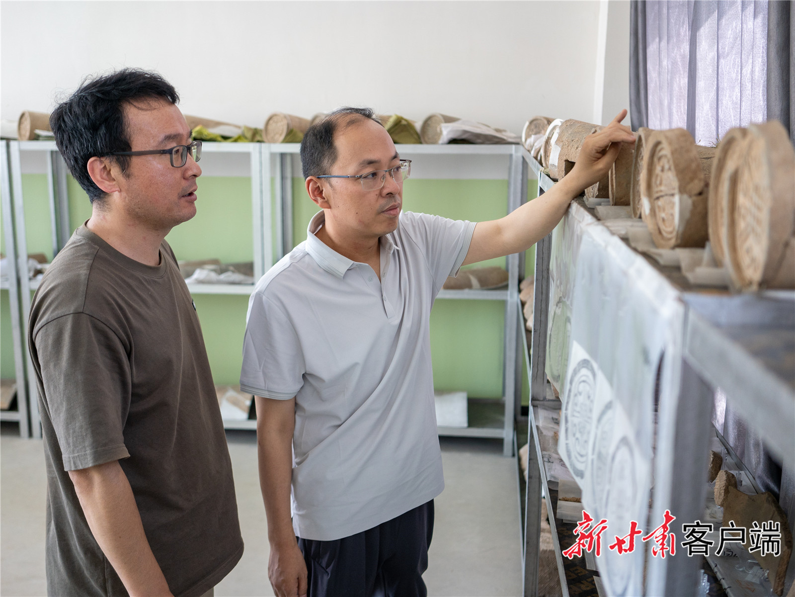 侯红伟（右一）与同事仔细查看四角坪遗址出土文物　新甘肃&middot;甘肃日报通讯员　樊一航