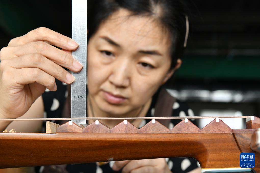 8月19日，工人在河北省肃宁县一家乐器生产企业车间内制作琵琶。