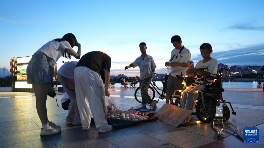 三位小伙在上饶市信州区的一处公园摆摊卖蒜。新华社记者胡晨欢 摄