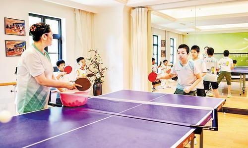 8月11日，在保定市竞秀区玉兰花园社区多功能运动教室，专业的乒乓球教练在带领孩子们进行专项训练。 侯虓摄