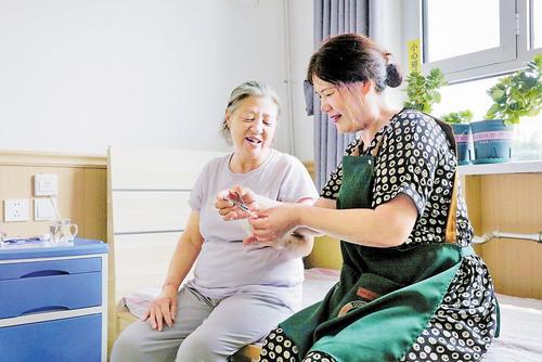 8月20日，在遵化市老年公寓，护理员（右）在照料老人。 本报记者 师源摄