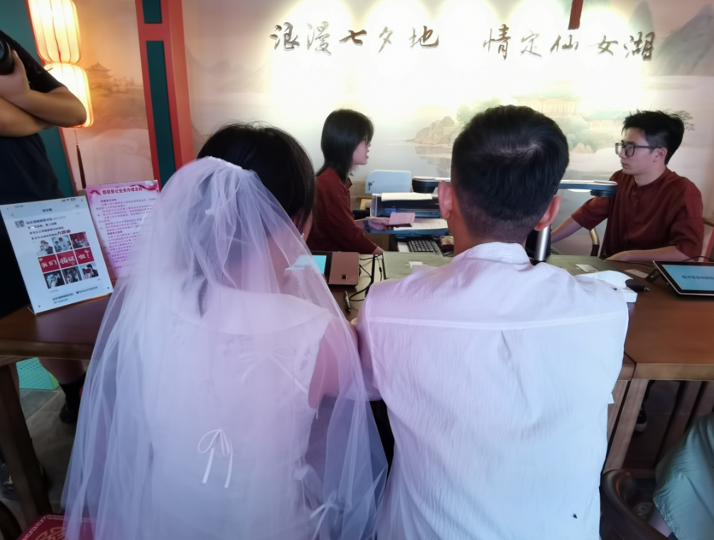 工作人員正在為首對前來登記的新人進行登記（李夢麗 攝）