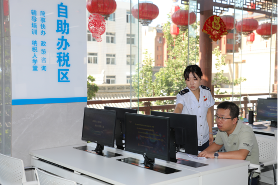 税务干部在“自助办税区”辅导纳税人办理涉税业务