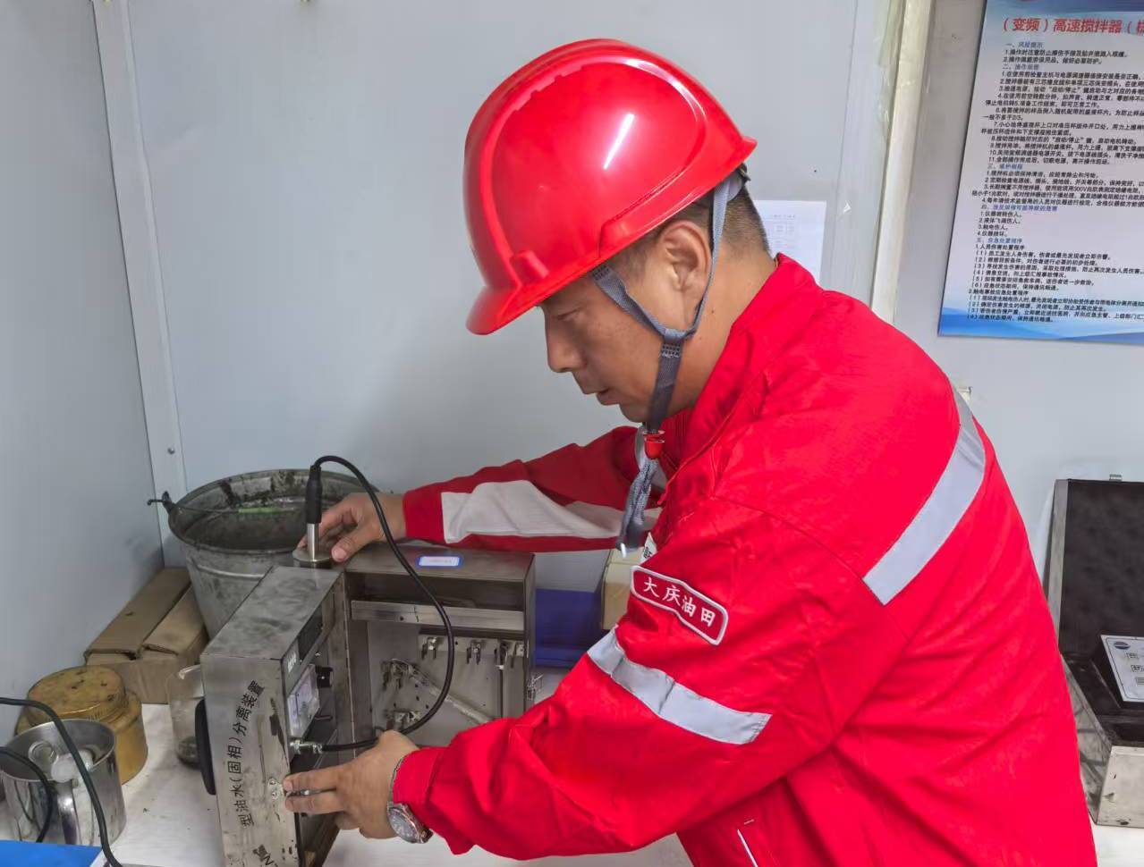 图为大庆钻探钻井液公司市场管理中心松辽项目部现场工程师马东凯正在移动实验室测量钻井液固相.jpg