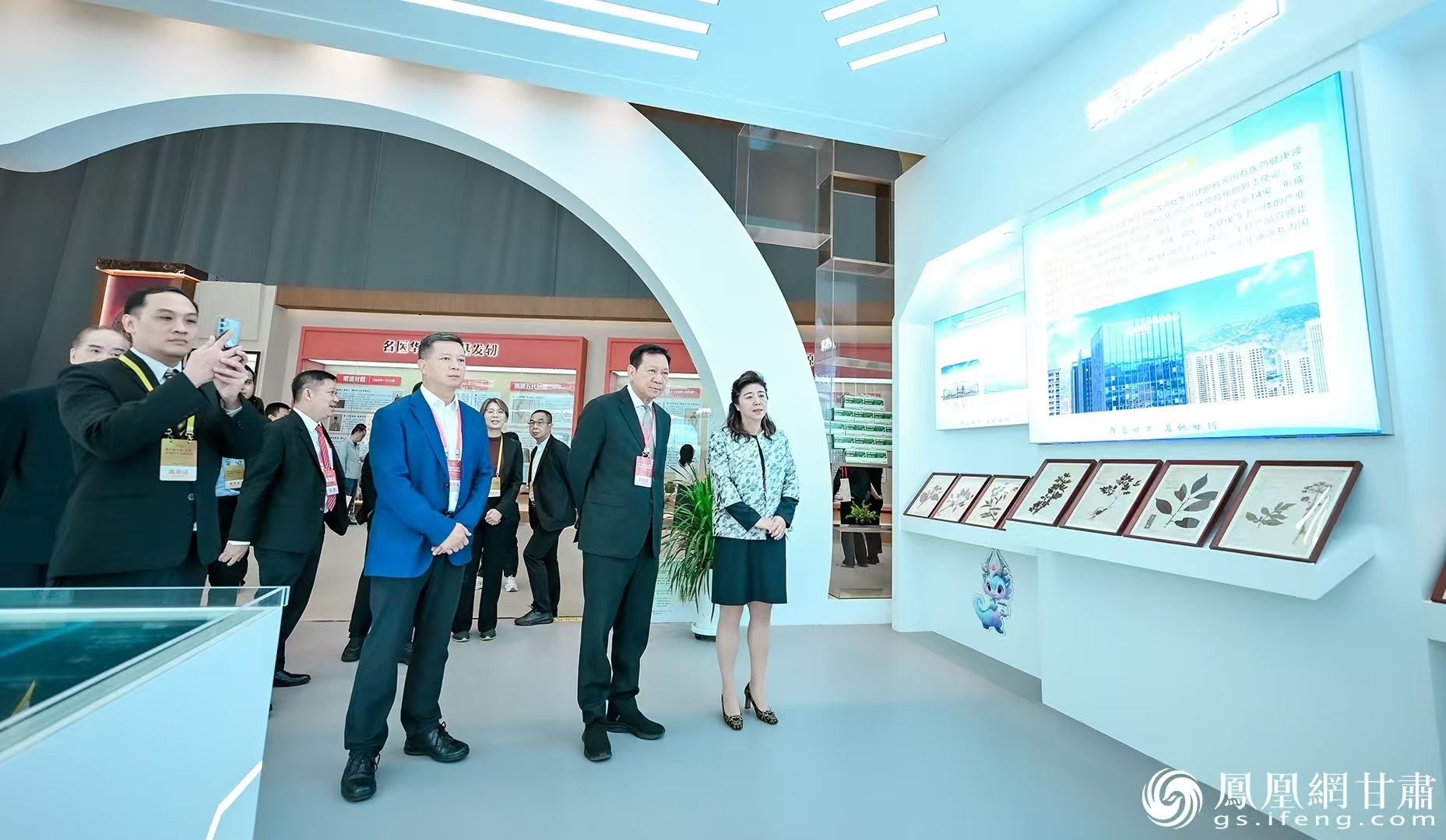 泰国公共卫生部部长顾问科希特•苏维尼吉(右二)走进甘肃药业集团展馆,了解中药材标准化种植基地建设情况。