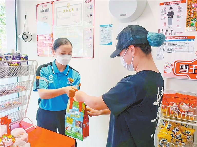 李茹月（左）把食物送到顾客手中。邱 桀摄