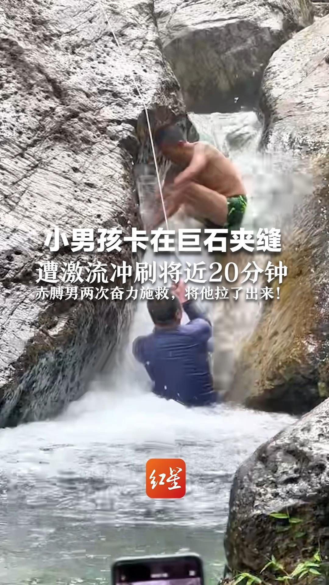 小男孩卡在巨石夹缝  遭激流冲刷将近20分钟  众人下堵上拉！赤膊男两次奋力施救，将他拉了出来