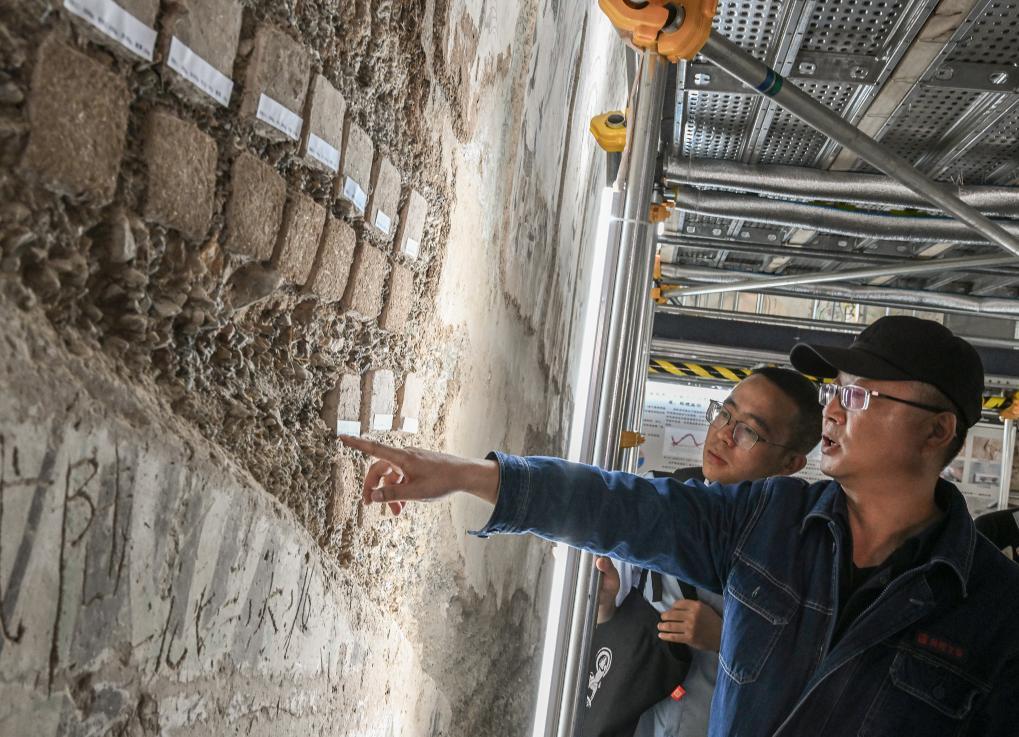 2023年8月3日，在敦煌莫高窟正在保护修缮的第55窟内，文保工作者对现场模拟试块进行对比测试。新华社记者　李贺　摄