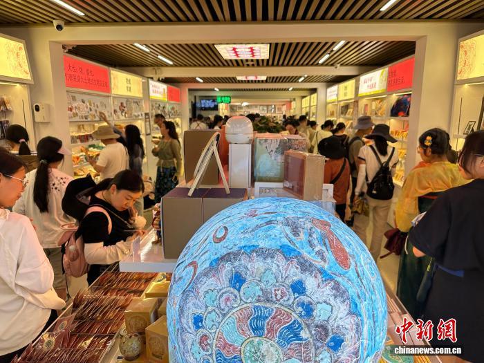 8月8日，游客在敦煌研究院文化创意馆购买文创产品。中新社记者　冯志军　摄