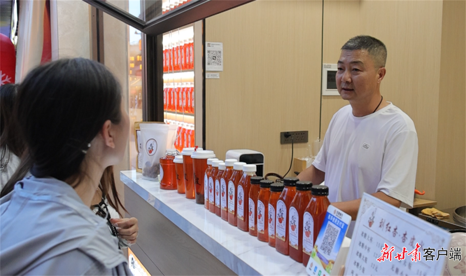 敦煌杏皮水制作技艺酒泉市级代表性传承人刘军向顾客介绍产品