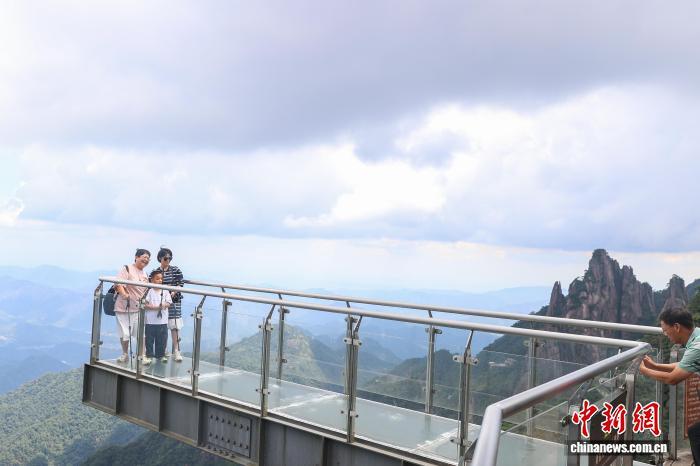 8月30日,江西上饶三清山,游客在玻璃栈道上拍照。中新社记者 刘力鑫 摄