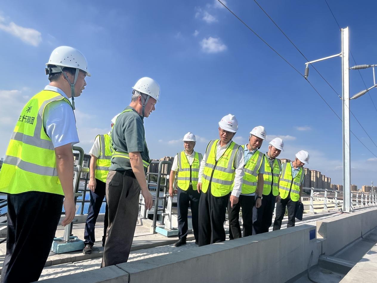 区长王勇登铁路桥面调研沿线环境整治情况。