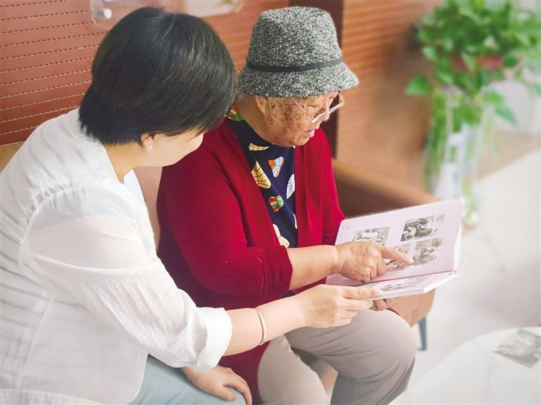 张奶奶(右)介绍老照片里的故事