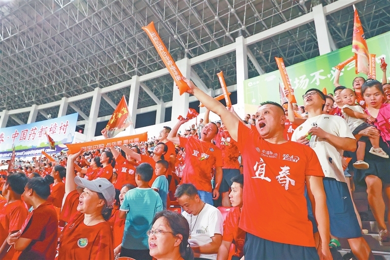 8月23日，樟树市体育中心，球迷在看台上为支持的球队加油呐喊。