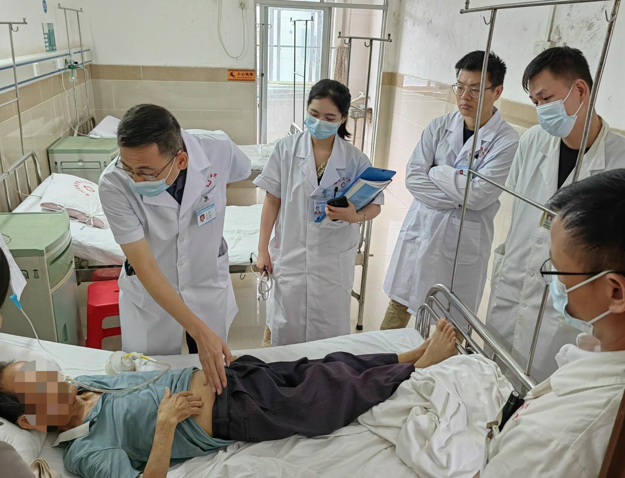 图为:在根子镇卫生院,以老带新教学查房。