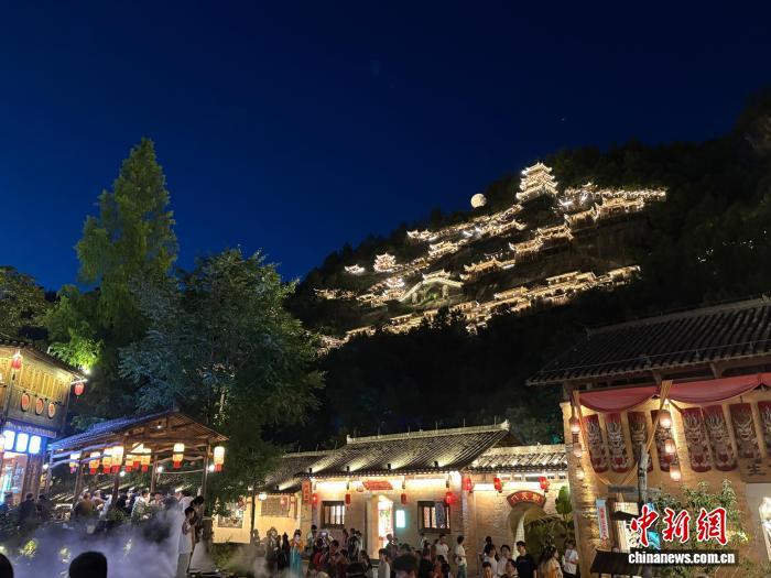 7月11日,江西望仙谷景区内悬崖边上的民宿千灯亮起,好似“天上宫阙”。中新社记者 李韵涵 摄