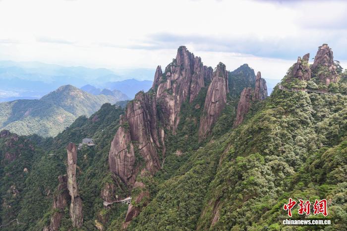 8月30日,江西上饶三清山,形态多样的花岗岩峰林伫立,游客行走在山体旁的高空栈道上。暑期进入尾声,世界地质公园、世界自然遗产地三清山人气不减,吸引不少游客前来观光游玩。“揽胜遍五岳,绝景在三清”,三清山以丰富的花岗岩地貌和奇特的峰林景观闻名于世,千峰竞秀、古树茂盛、珍禽栖息,同时也是一座道教名山。中新社记者 刘力鑫 摄