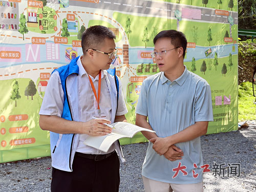 本报全媒体记者、派驻铜鼓县新闻导师洪怀峰(左)采访来铜鼓县投资兴业的客商。通讯员 张子良摄
