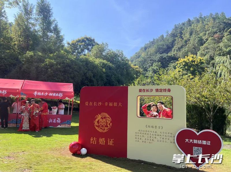新人在“超大结婚证”背景板前打卡。长沙晚报全媒体记者 刘俊 摄