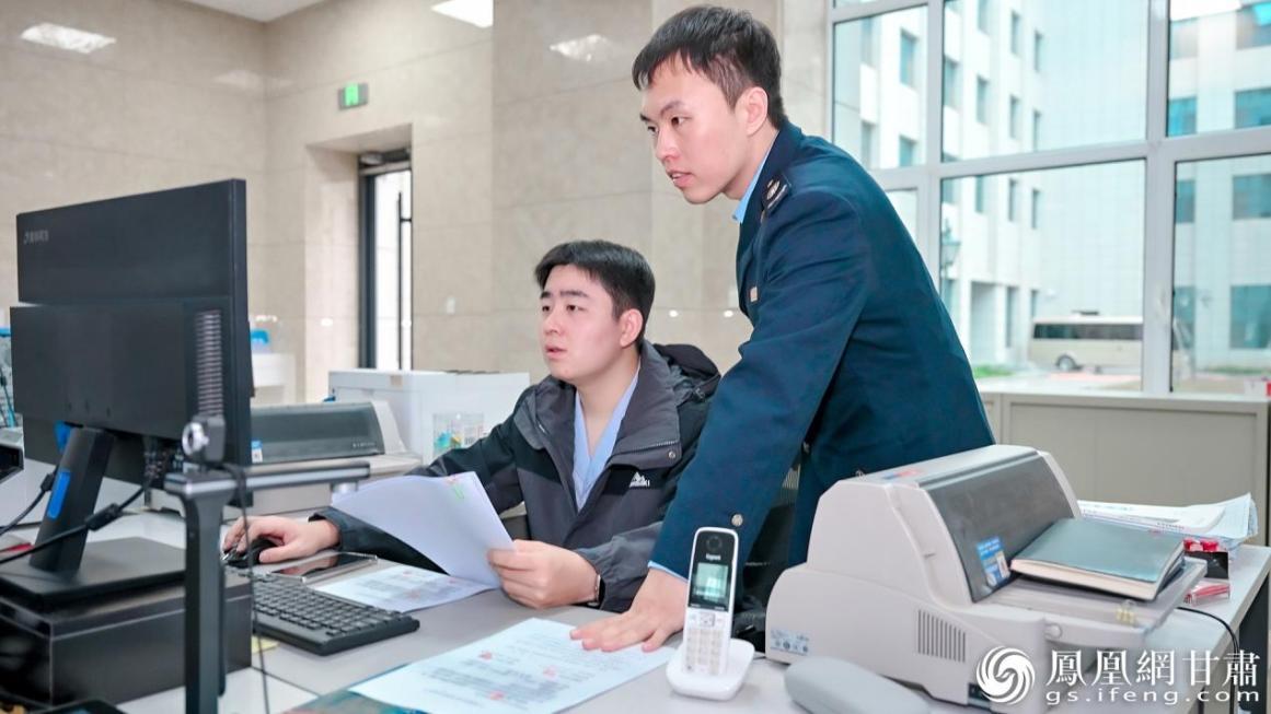 兰州新区办税大厅内，工作人员（右）为企业提供网上办税指导。