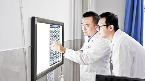 8月26日,首都医科大学附属北京朝阳医院胸外科副主任、张家口市第一医院院长王洋(左)在诊断患者病情。