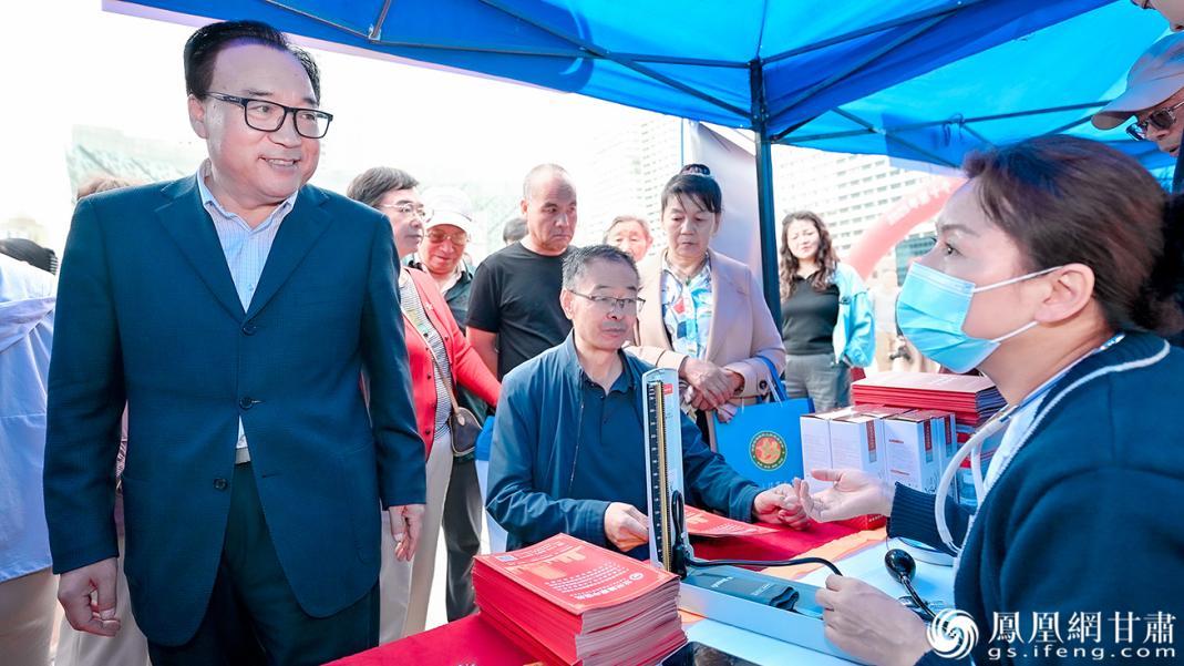 甘肃省慈善联合总会会长李志勋(左)参观爱心义诊展台