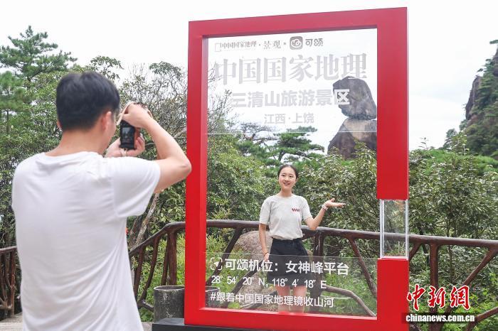 8月30日,江西上饶三清山,游客在三清山标志性景观神女峰前拍照。中新社记者 刘力鑫 摄