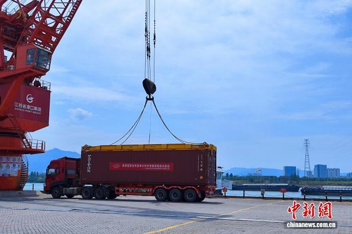 9月4日，在江西省吉安市吉州区石溪头码头，一个集装箱吊装上船。吉安市交通运输局 供图