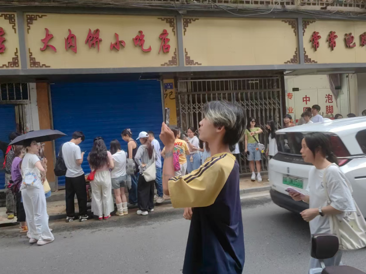 一位博主在“一毛钱”奶奶摊位前直播
