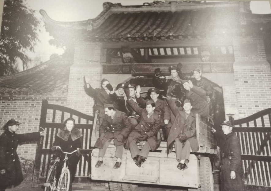 飞虎队第14航空队几名飞行员乘卡车离开重庆,图为他们在重庆居民区入口大门前的合影