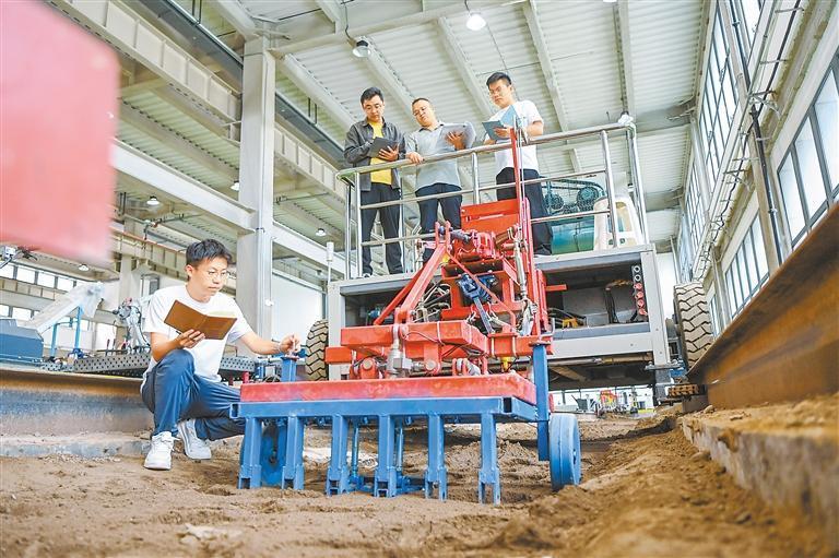 戴飞（右二）带领学生结合实际改进农机设备