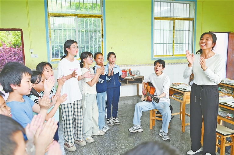 4月29日,丰城市蕉坑乡力富小学,聂卫珍(右一)、卢汉琪(右二)两名老师将孩子们聚在一起,利用课余时间练习合唱,激发孩子们对音乐的热爱和兴趣。