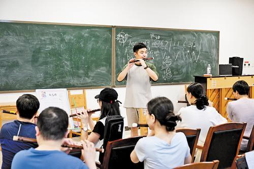 近日，河北省群艺馆青年夜校老师在教学员吹奏笛子。 本报记者 史晟全摄