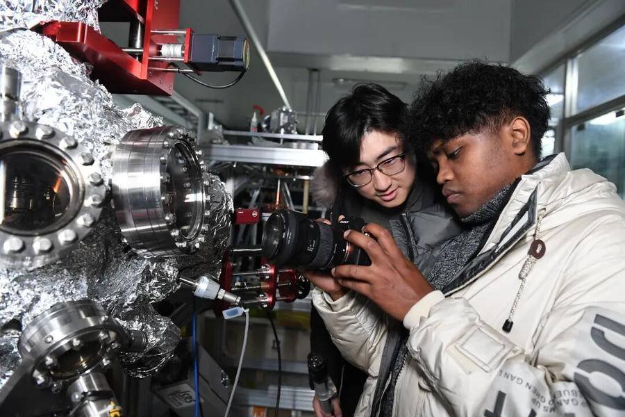 杨远帆和团队成员马达加斯加留学生在实验室工作。（资料图）