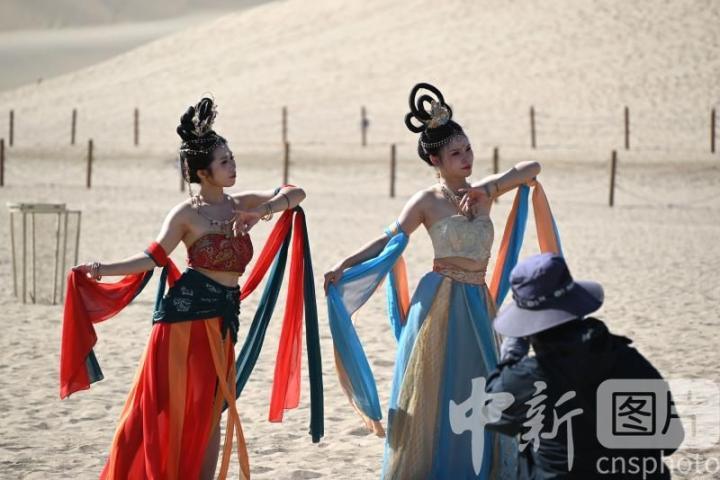 9月6日，游客在甘肃省敦煌市鸣沙山月牙泉景区拍照。中新社发　张晓亮　摄