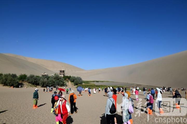 9月6日，游客在甘肃省敦煌市鸣沙山月牙泉景区游览。中新社发　张晓亮　摄