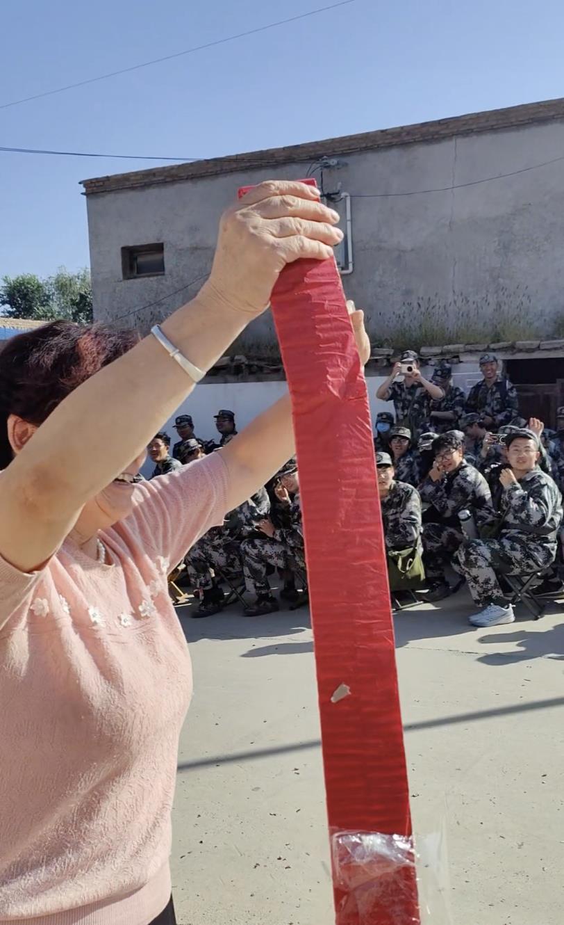 村民罗女士放鞭炮欢迎学生到来（图源：受访者郭先生）